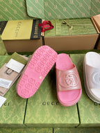 Pink logo slide sandals with embossed footbed and emblem on wide strap