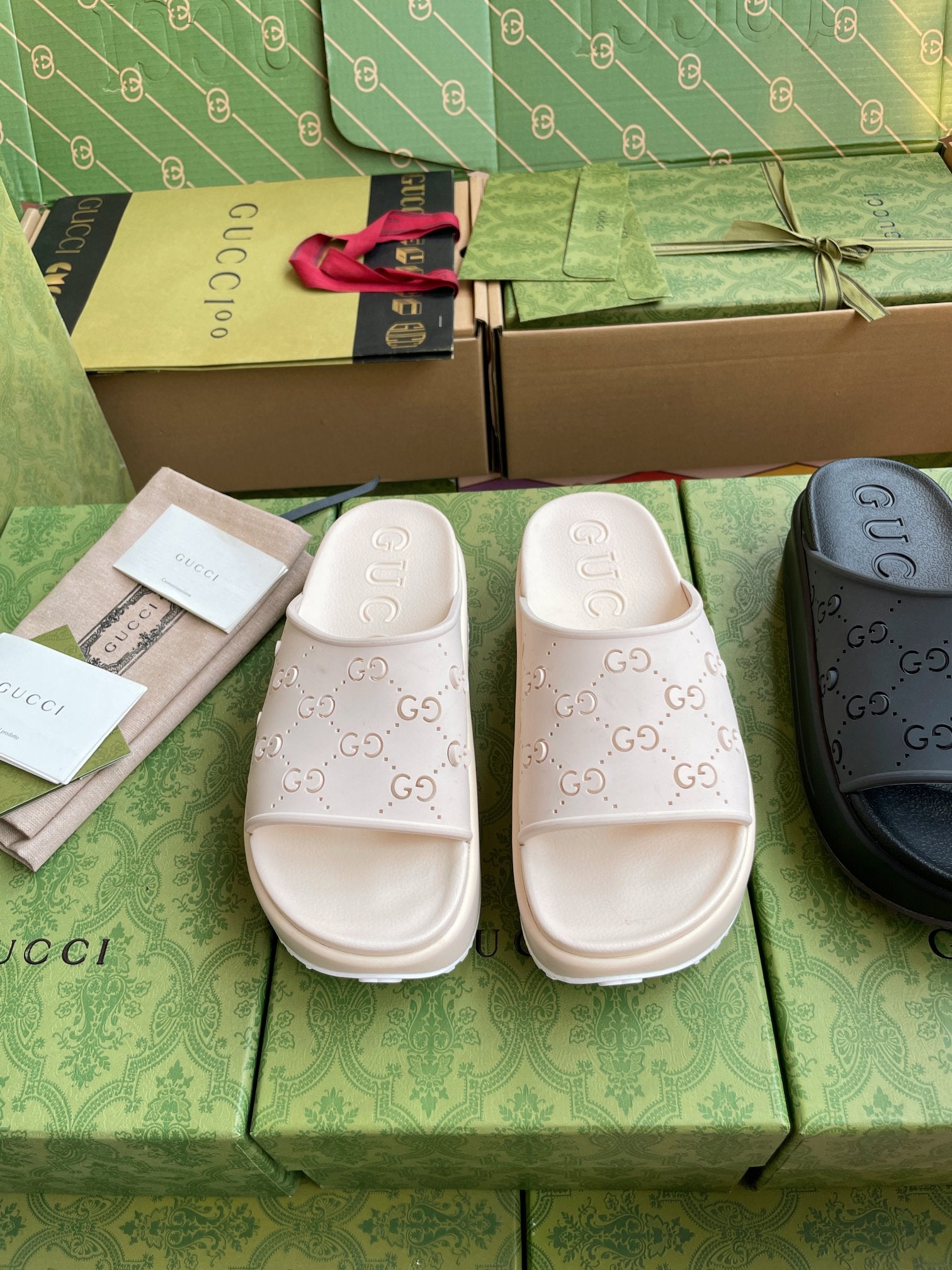 GG logo slide sandals in white, embossed pattern on straps and cushioned sole