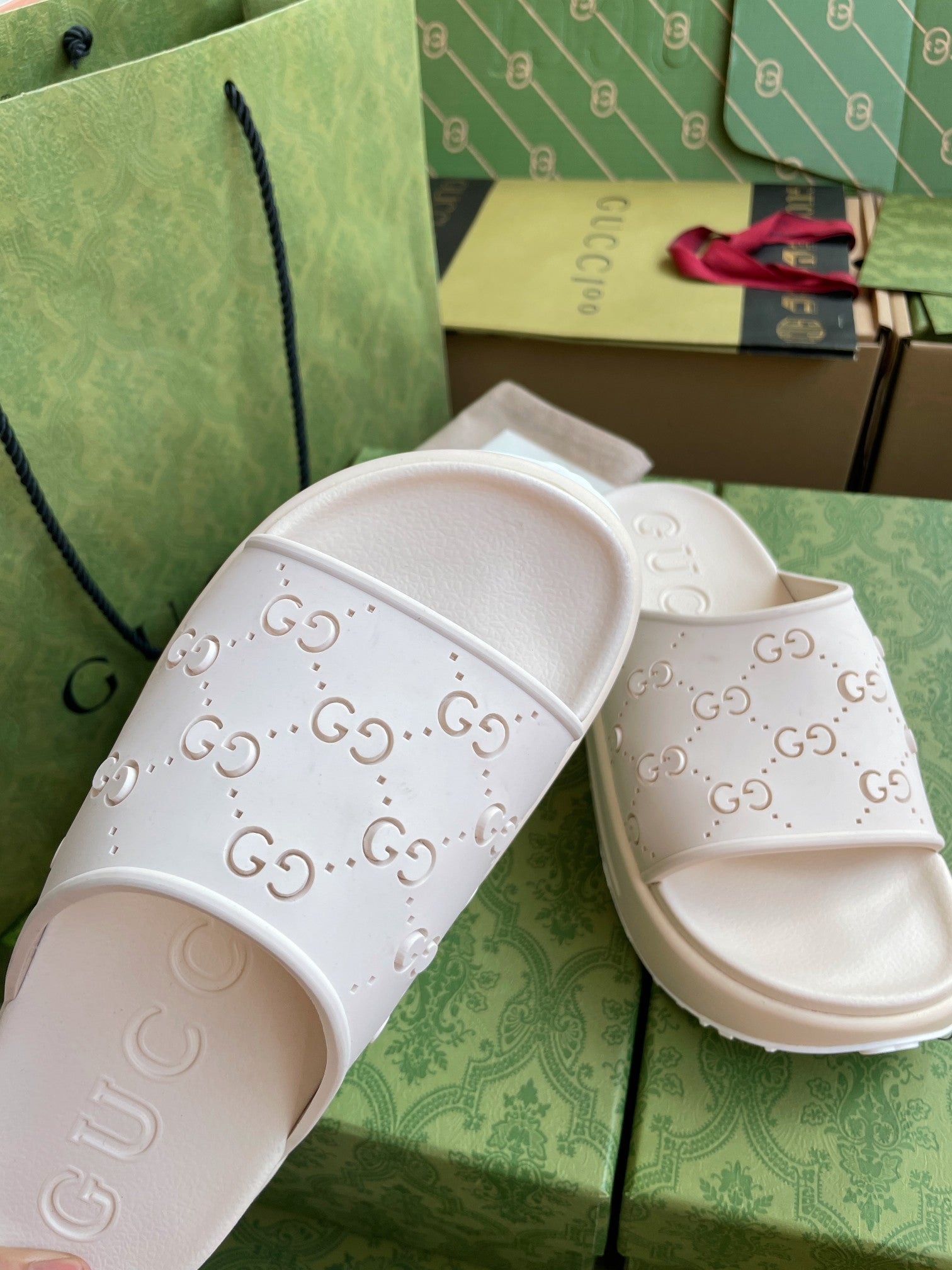 White GG logo slide sandals with embossed straps and curved cushioned footbed