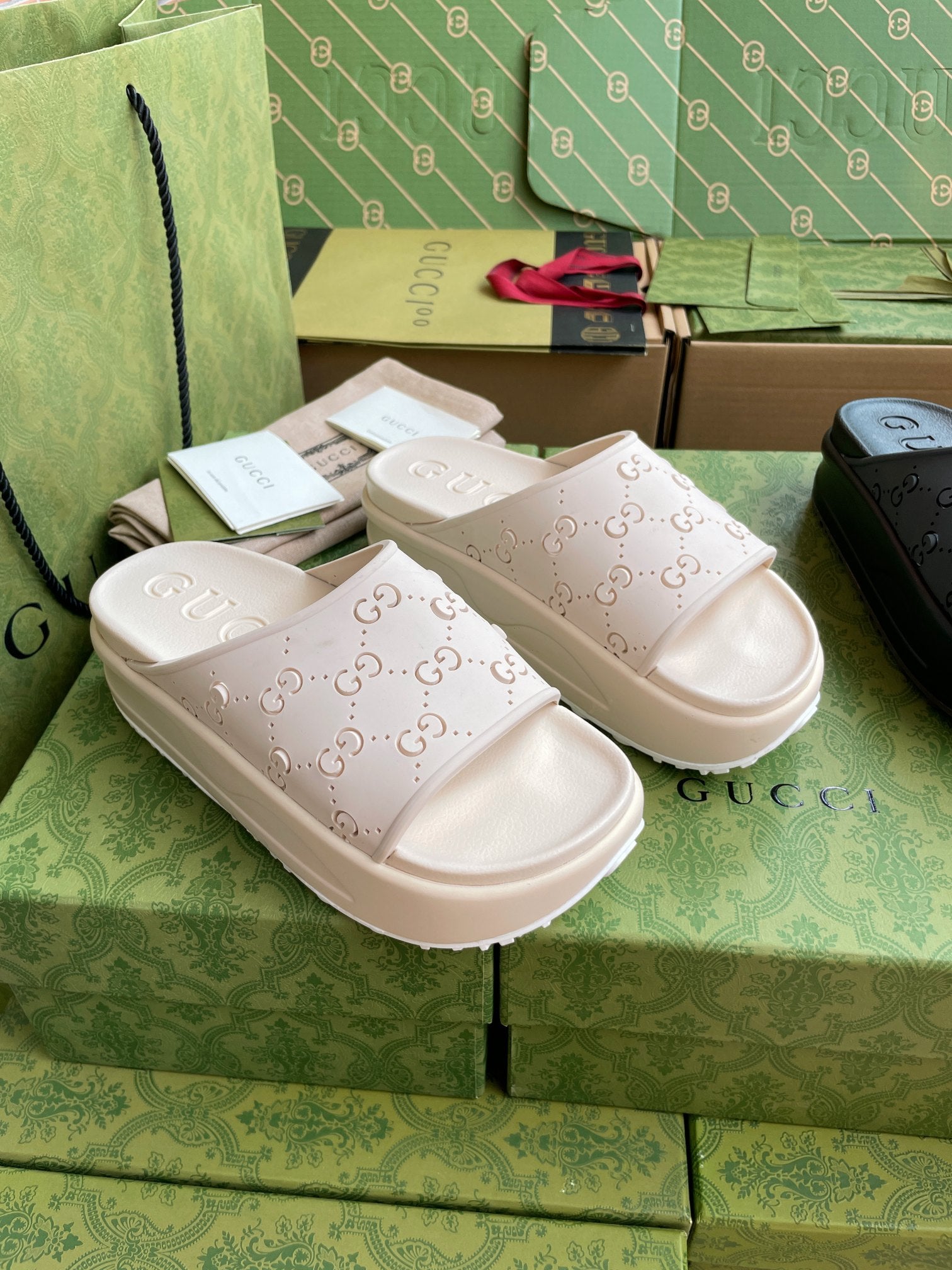 Pair of white GG logo slide sandals with embossed straps and platform sole