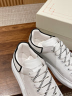White lace-up sneakers with black collar trim, side view of stitched panels