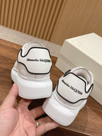 White Alexander McQueen sneakers with black-trim heel and logo back tab