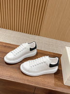 Alexander McQueen white leather low-top sneakers with black heel accents, side view
