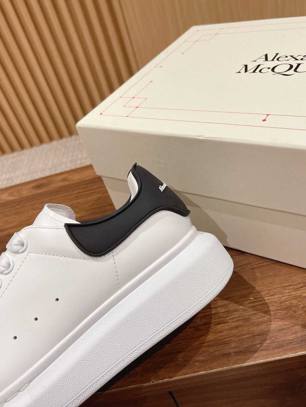 Alexander McQueen white sneakers with black slip-on heel panel, close side view