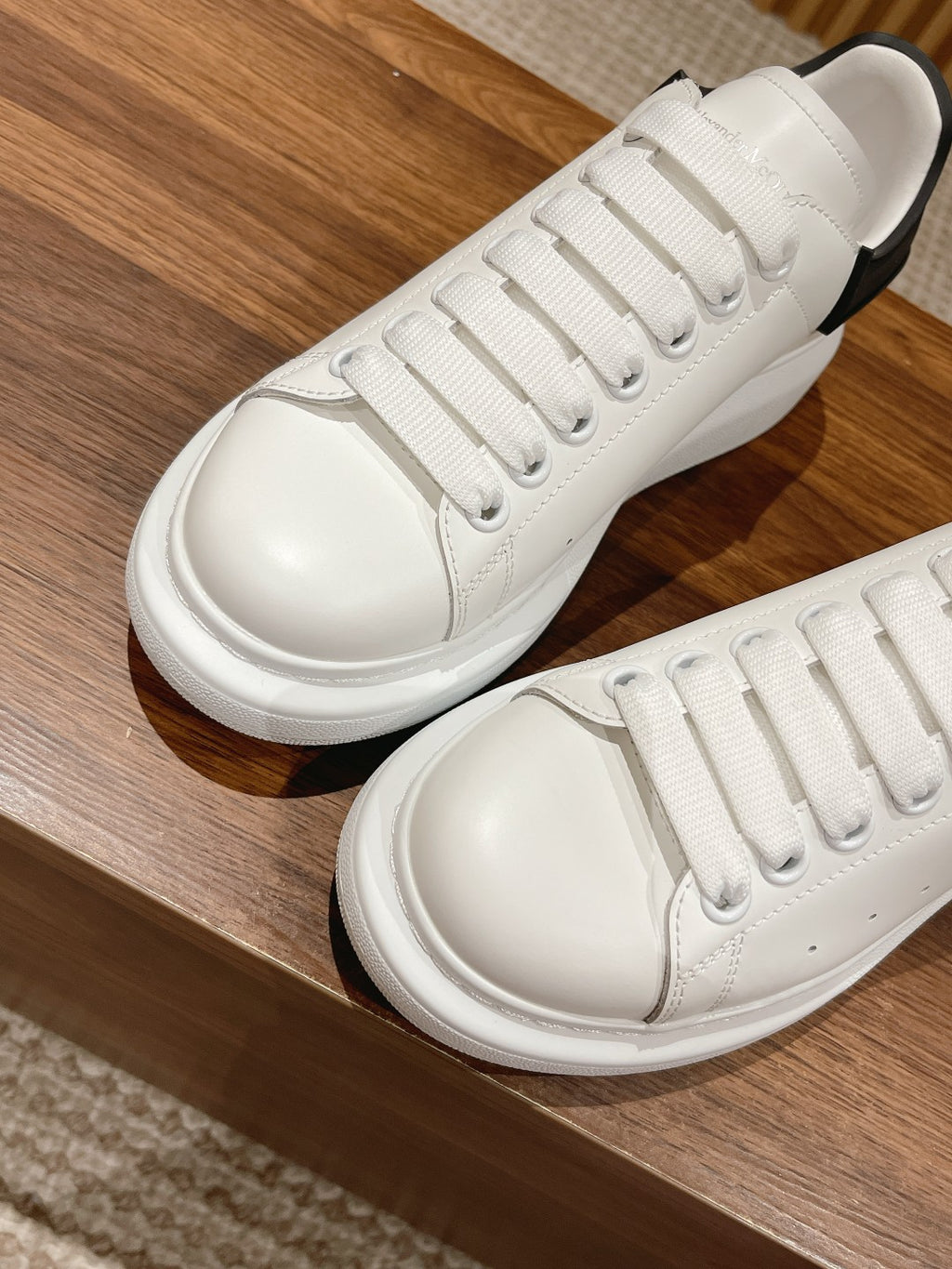 Alexander McQueen white lace-up sneakers with black heel trim, top view