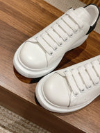 Alexander McQueen white lace-up sneakers with black heel trim, top view