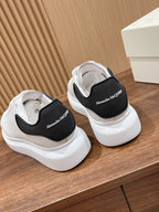 Alexander McQueen white sneakers with black tongue lining, open rear view