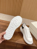 Alexander McQueen white sneakers with black heel trim, outsole view