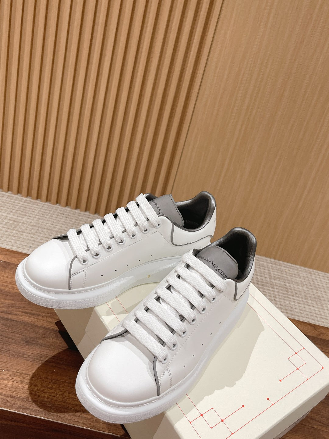 Two-tone Alexander McQueen sneakers in white with gray panels and lace-up