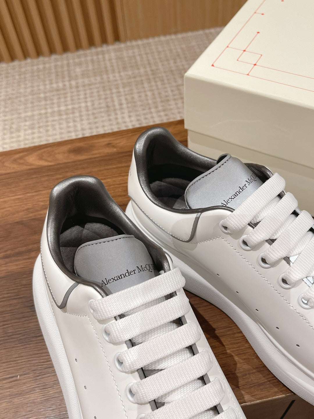 Alexander McQueen white sneakers with gray side panels and embossed heel logo