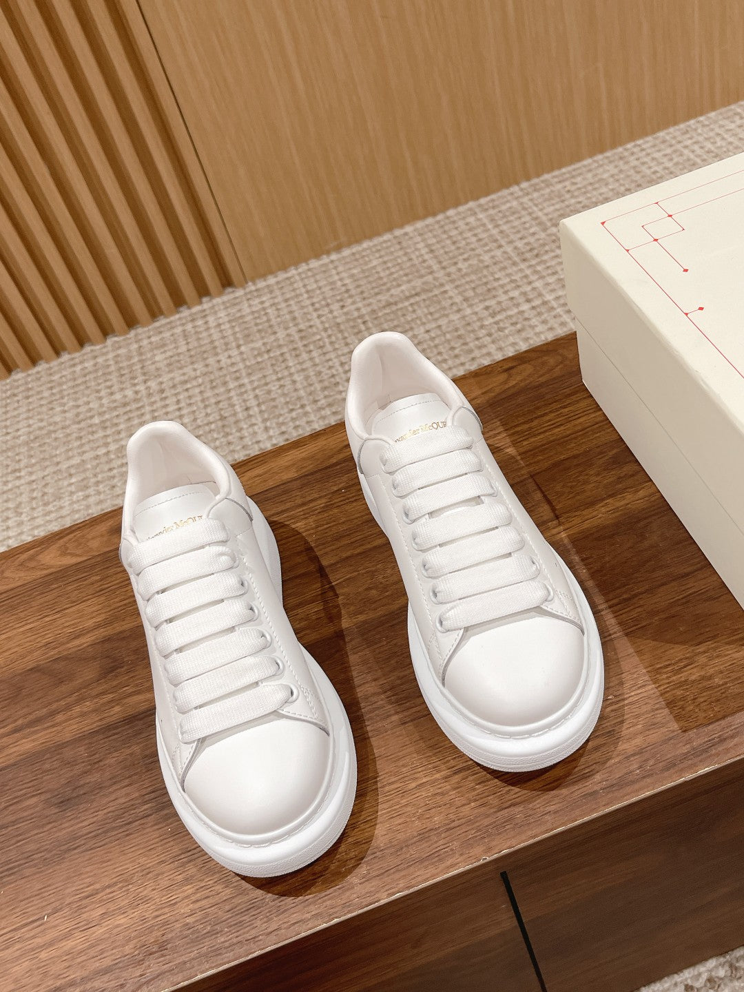 Alexander McQueen white lace-up sneakers, side view with flat rubber sole