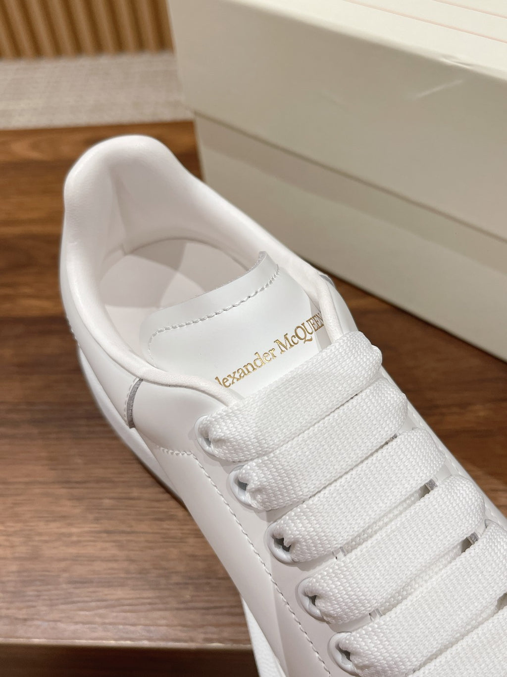 Alexander McQueen white sneakers, close-up of stitched tongue with logo
