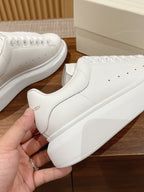 Alexander McQueen white leather sneakers, close-up front quarter and side panel