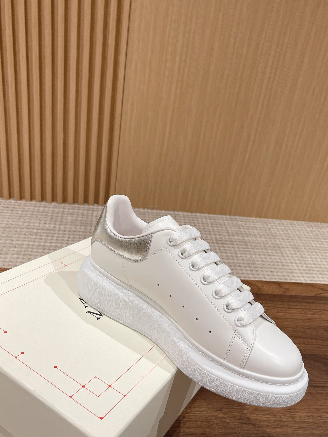 White lace-up sneakers with stitched panels and textured sole