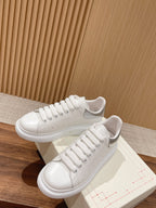 White lace-up sneakers with off-white laces and perforated toe