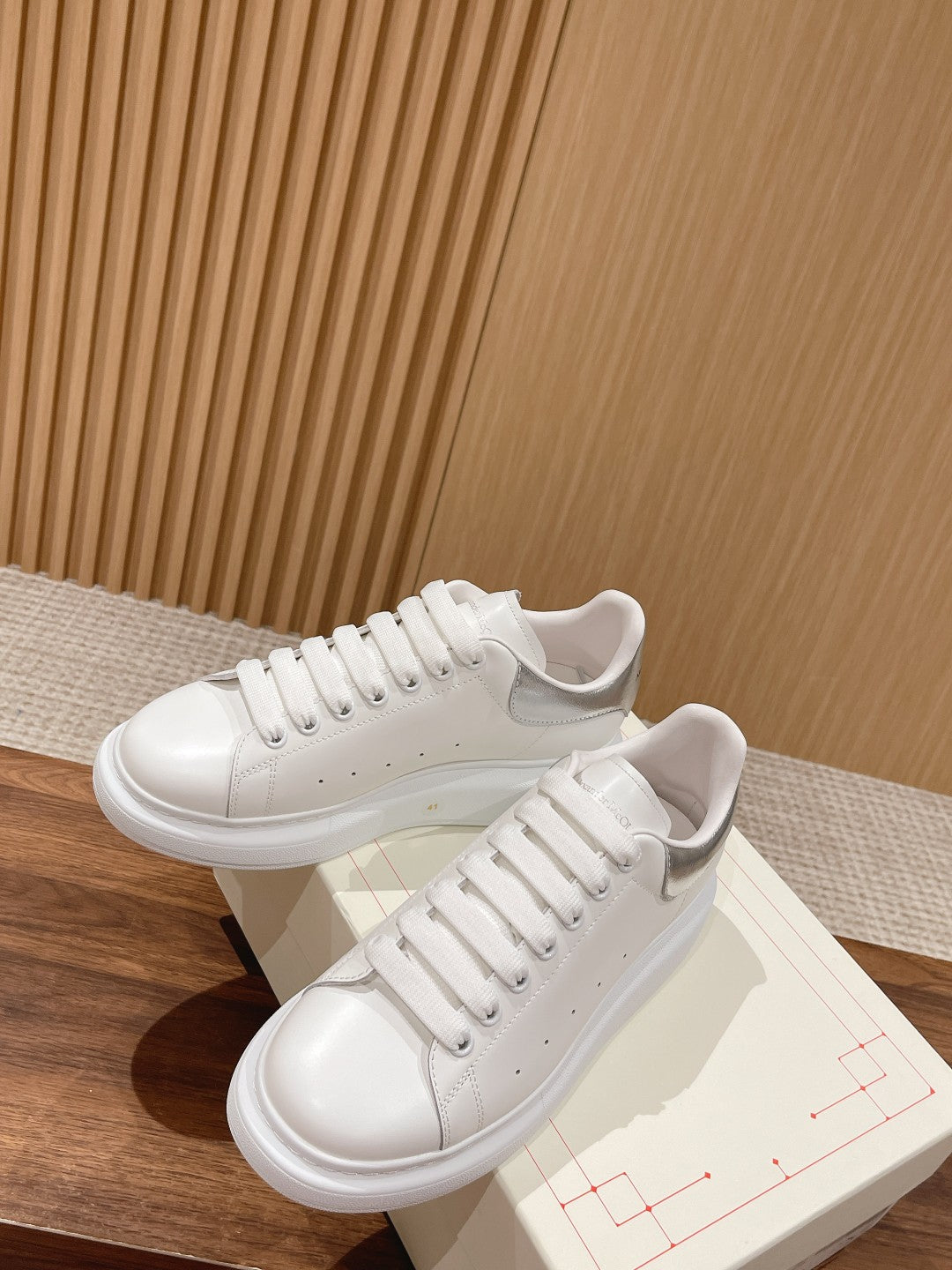 White lace-up sneakers with off-white laces and perforated toe