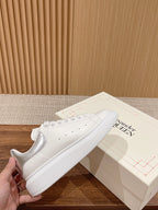 White lace-up sneakers with perforated details and smooth toe
