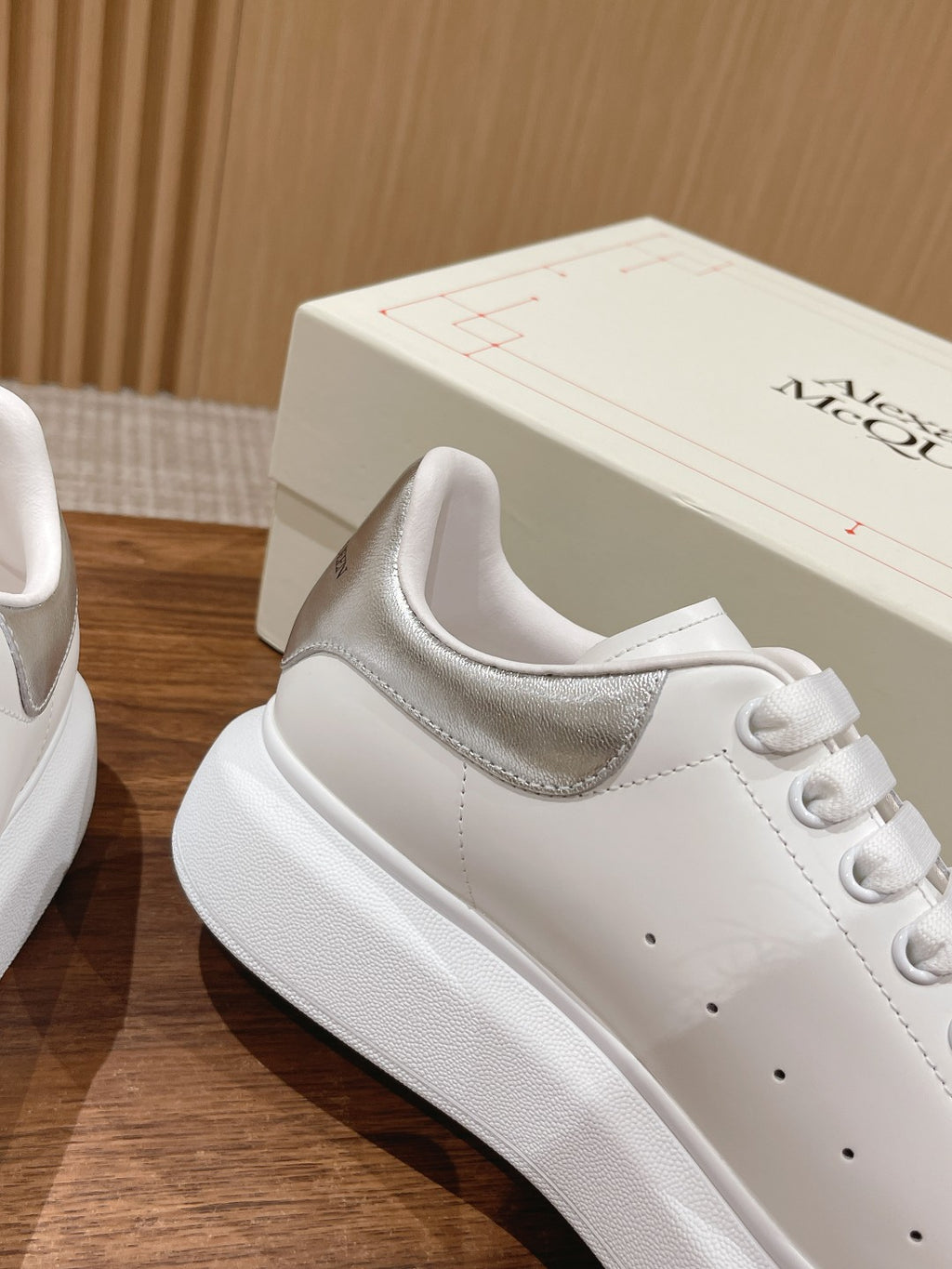 White sneaker with cushioned collar, lace eyelets, and embossed branding