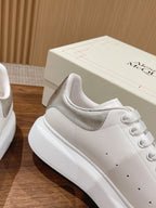 White sneaker with cushioned collar, lace eyelets, and embossed branding