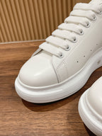 Close-up of white lace-up sneakers with thick textured rubber sole