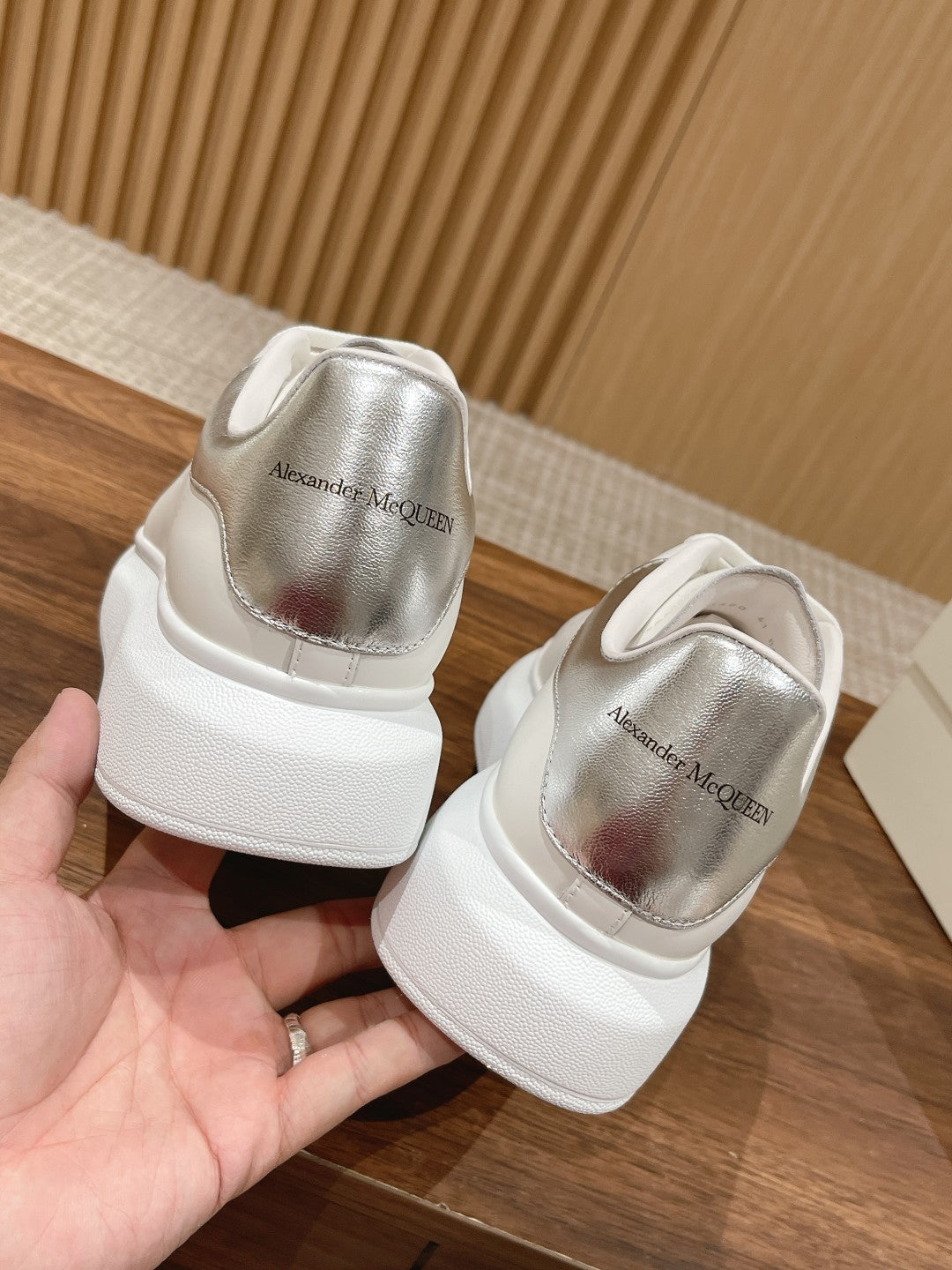 Back view of white sneakers with Alexander McQueen branding on heel