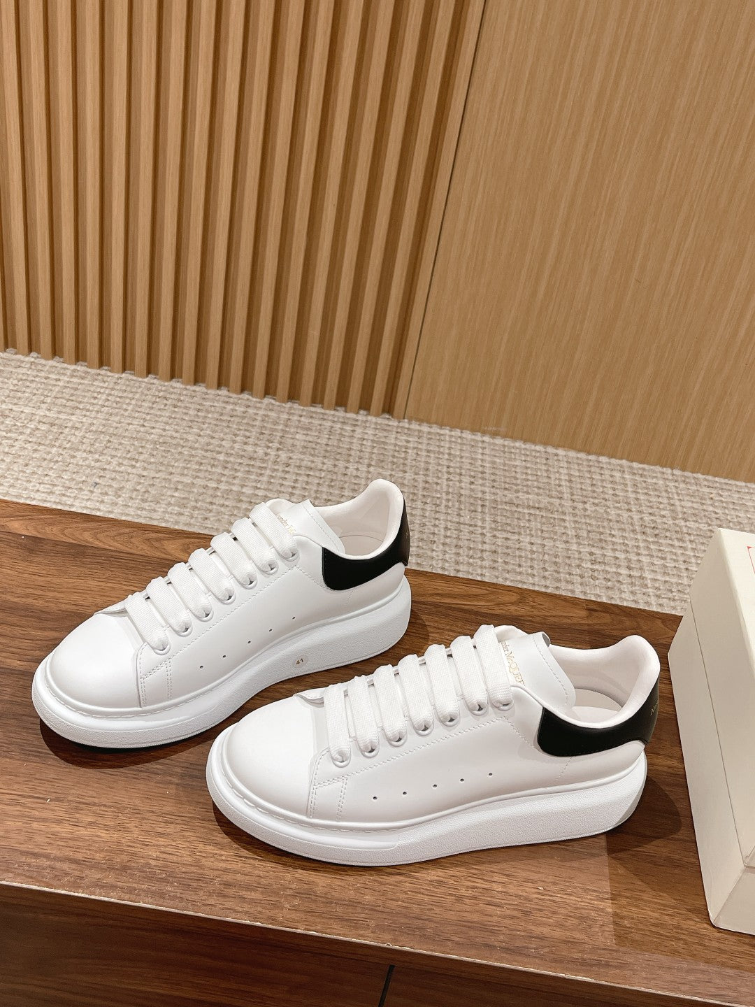 White leather lace-up sneakers with black heel tab, rounded toe, cupsole
