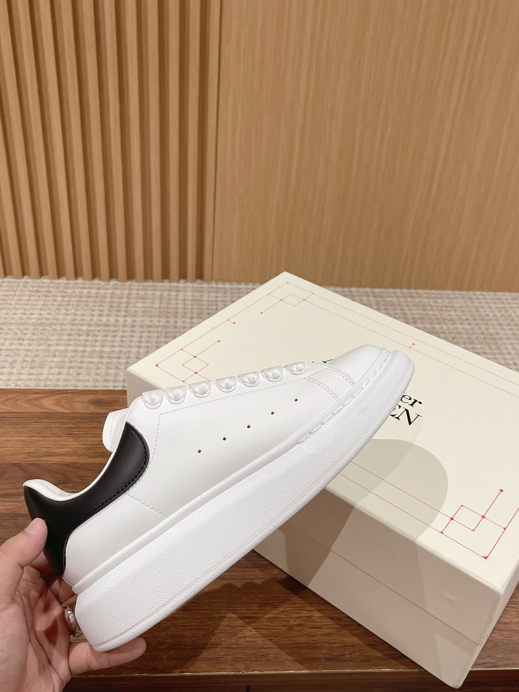 White leather sneakers with black heel detail and lace-up front, low-profile sole