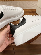 White leather sneakers with black heel patch and Alexander McQueen logo, lace-up