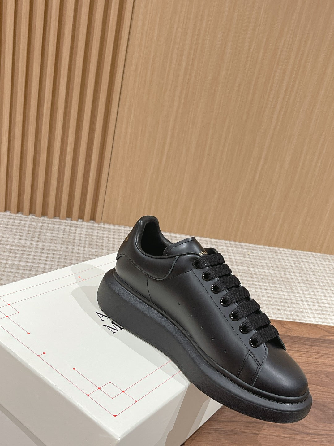 Black low-top lace-up sneakers with smooth leather upper and stitched toe cap