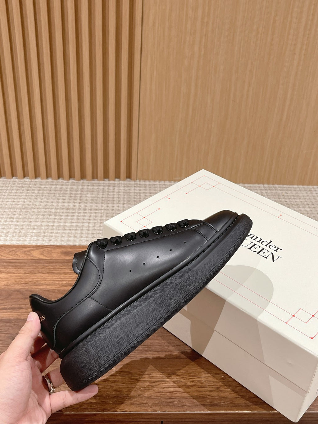 Black leather lace-up sneakers with rounded toe and sculpted sidewall sole