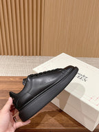Black leather lace-up sneakers with rounded toe and sculpted sidewall sole