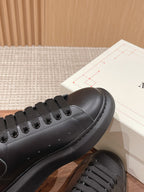 Close-up of black lace-up sneaker toe with stitched leather panels