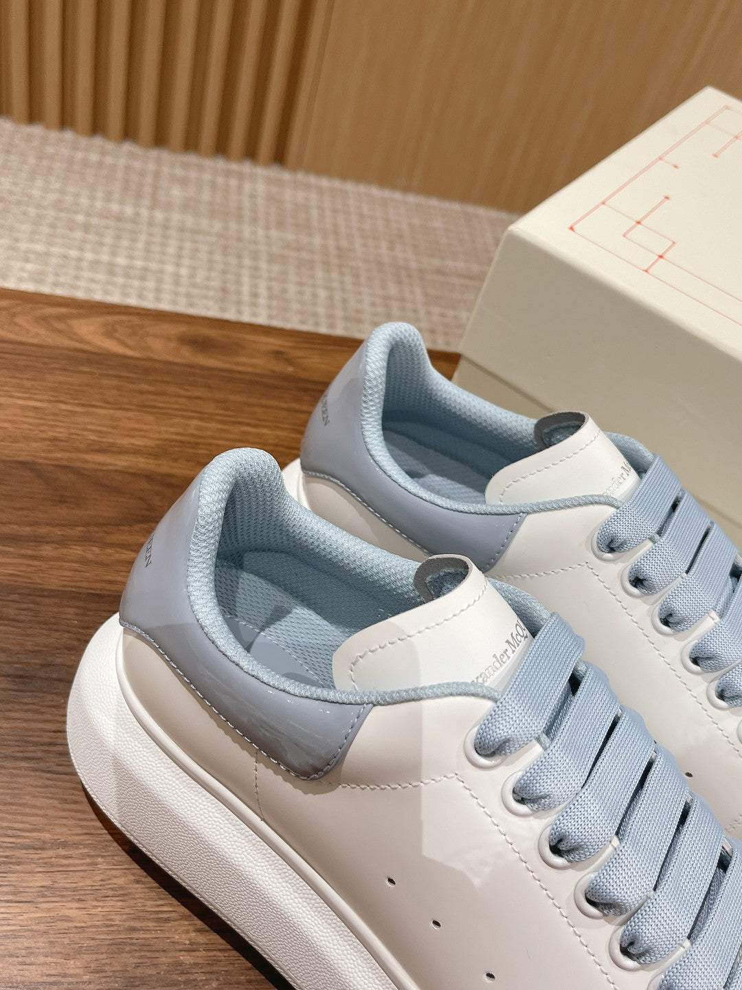 Alexander McQueen low-top sneakers, rear angled view with light blue padded collars