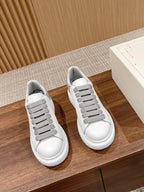 White low-top sneakers with gray lace trims and lace-up front