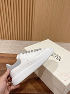 White leather Alexander McQueen sneakers with gray laces and perforated toe