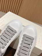 Close-up of white sneakers with gray elastic lace sections on top