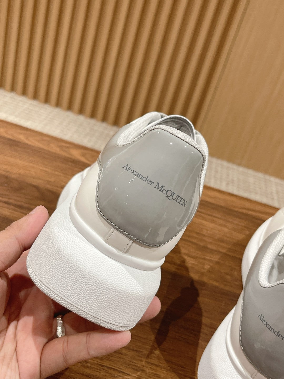 White sneaker heel with gray logo patch on the back tab