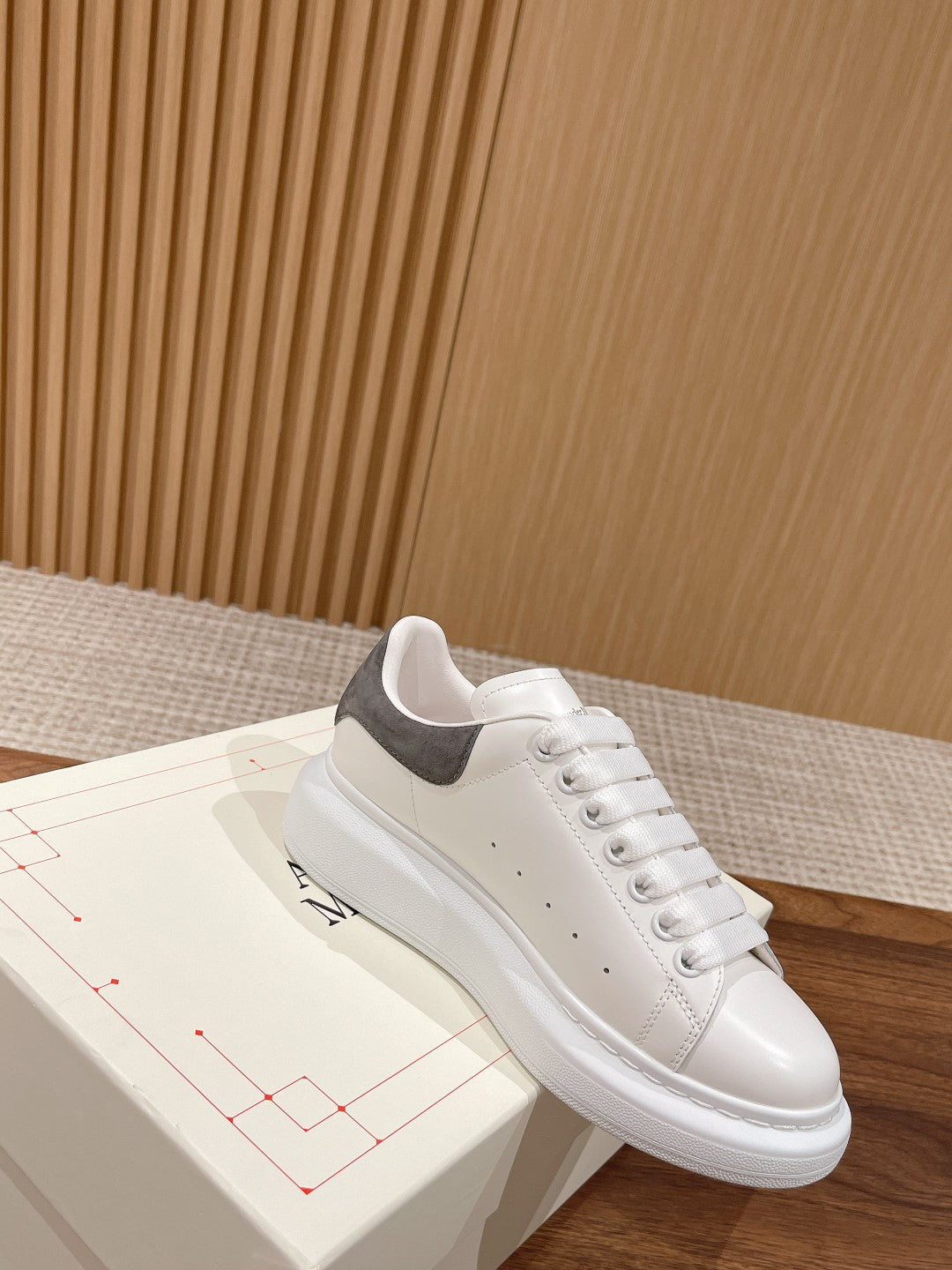 White leather low-top sneakers with gray suede heel and lace-up design
