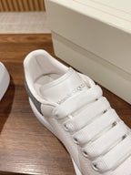 White lace-up sneaker showing padded tongue lining with text logo