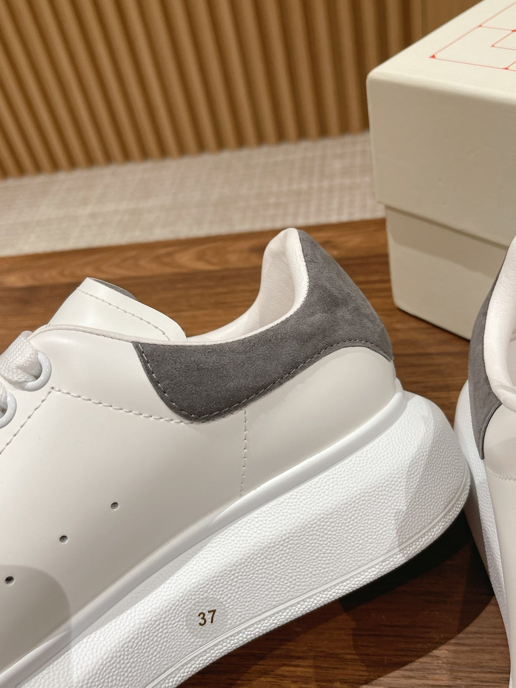 White leather sneakers with gray suede collar and side stitching, flat rubber sole