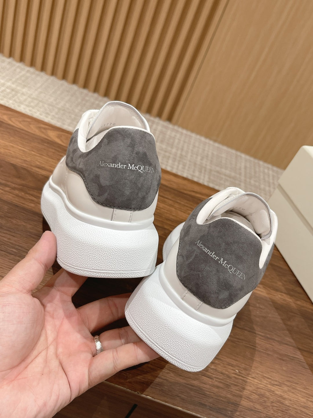 White leather sneakers with gray suede heel lining, rear view with lace-up openings