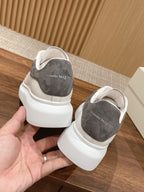 White leather sneakers with gray suede heel lining, rear view with lace-up openings