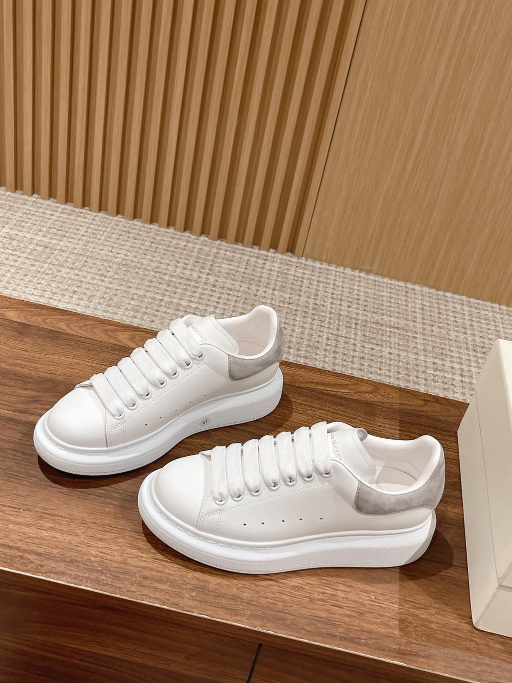White leather low-top sneakers with lace-up and side panel perforations