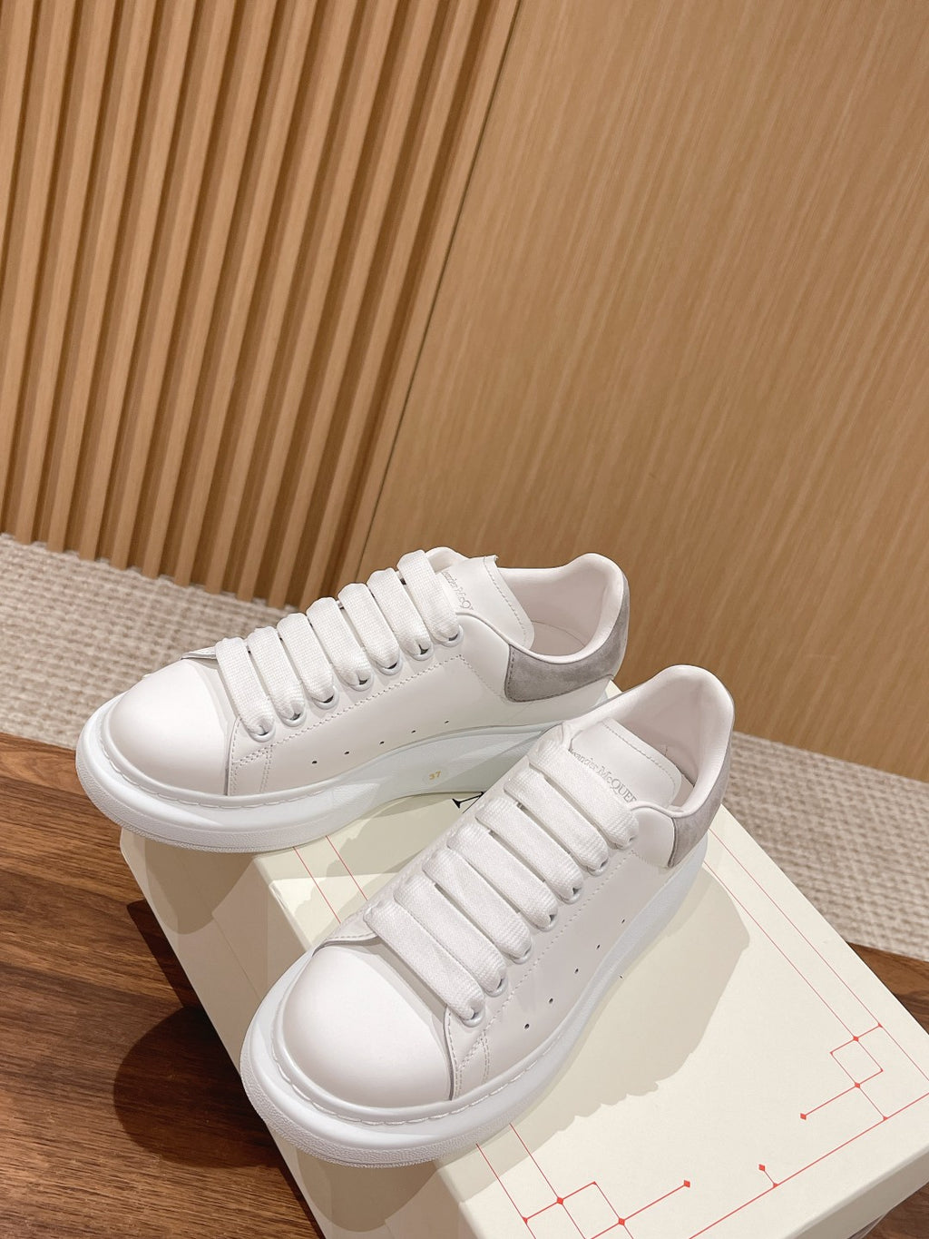 White leather lace-up sneakers on box, padded tongue and rubber sole