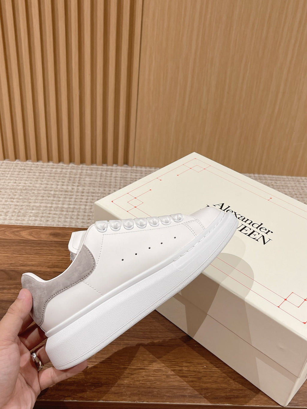 White leather low-top sneakers with lace-up, signature toe perforations