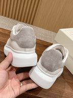 White leather sneakers with gray suede heel panels and cushioned back