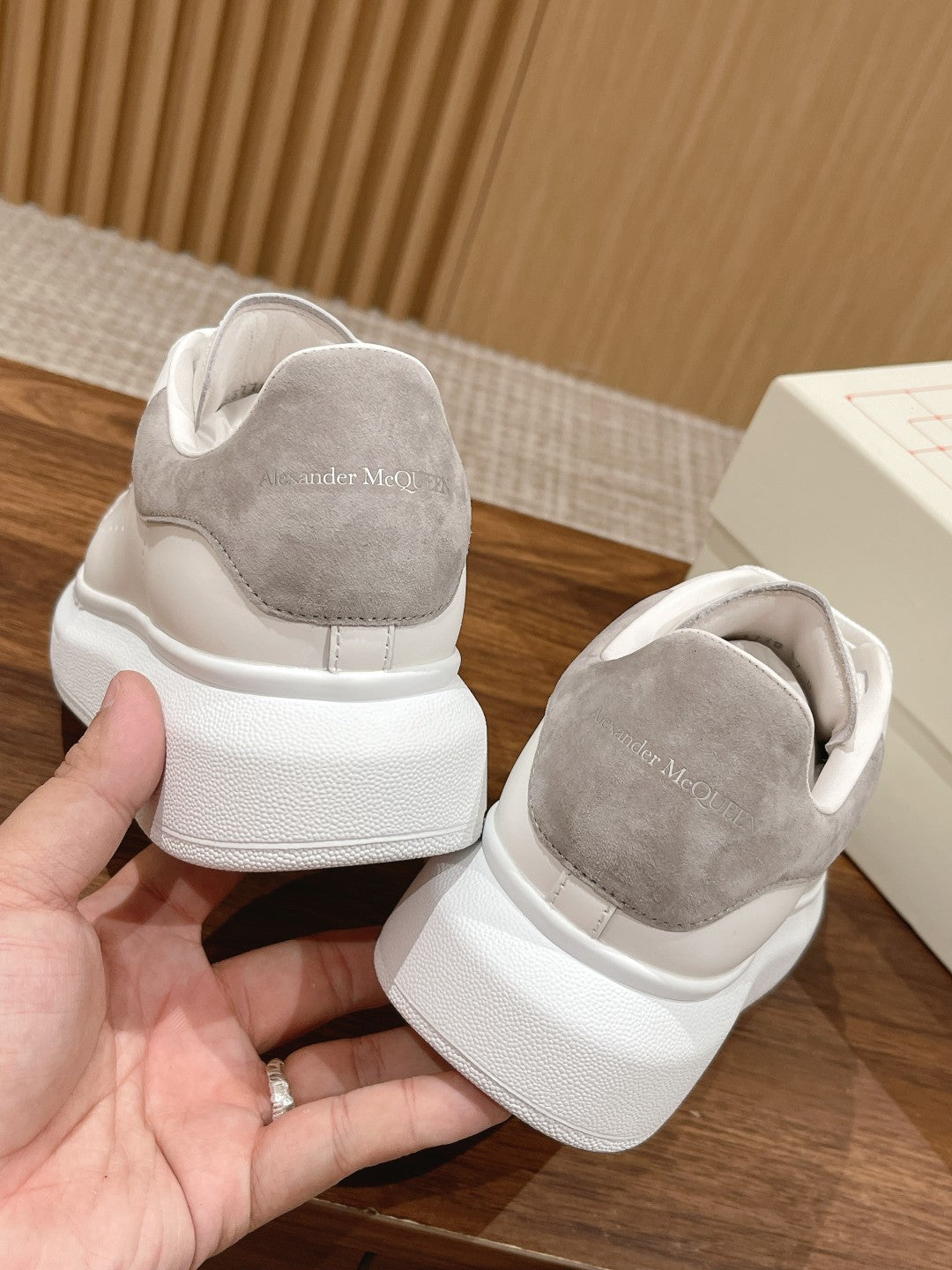 White leather sneakers with gray suede heel panels and cushioned back