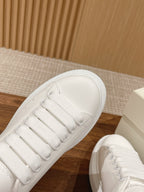 White leather sneakers close-up of lace and stitched toe cap