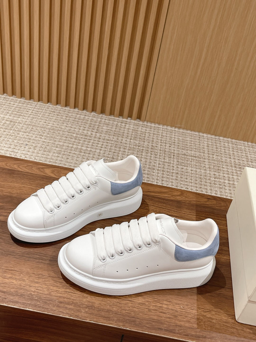 White leather lace-up sneaker with light blue heel trim and smooth white rubber sole