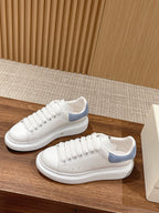 White leather lace-up sneaker with light blue heel trim and smooth white rubber sole